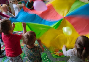Dzieci bawią się w odbijanie balonów na chuście animacyjnej